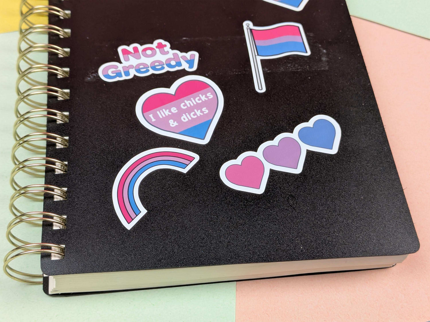 Black notebook with colorful stickers on a multicolored background