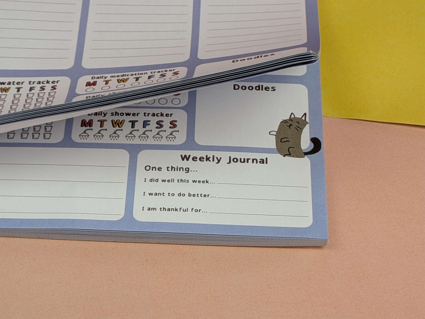 Image showing the pages flipped up, this is a desk planner with daily trackers.