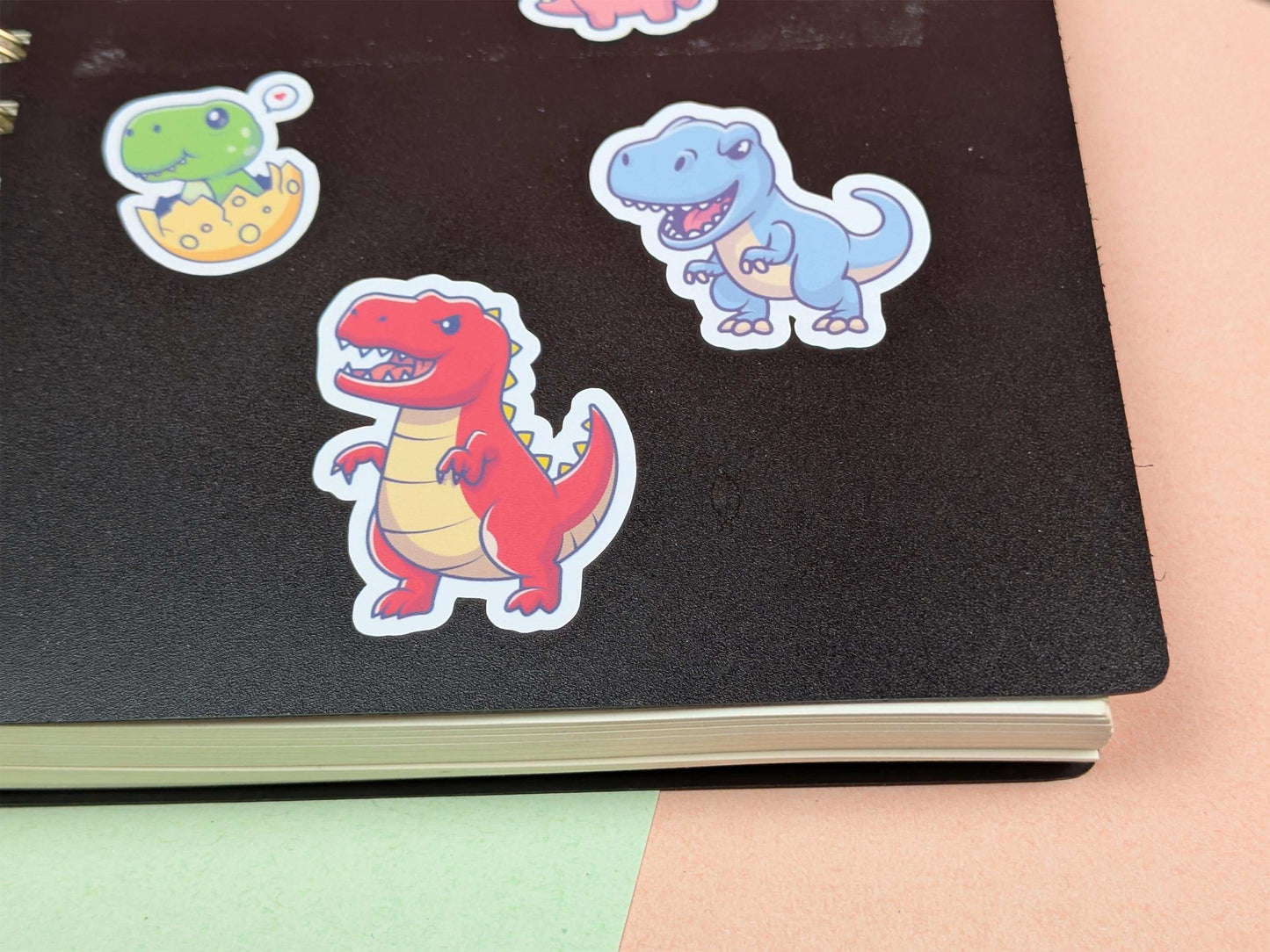 Colorful dinosaur stickers on a black surface