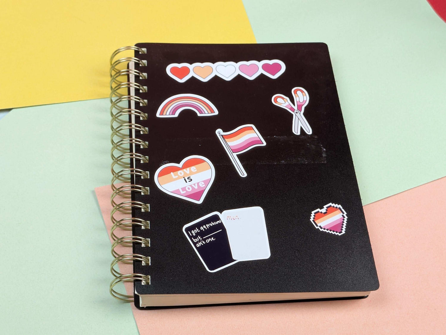 Black notebook with colorful stickers on a multicolored background