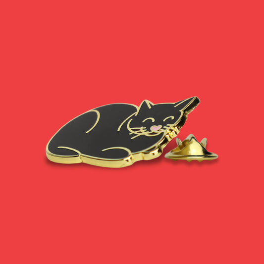 Black cat-shaped pin with gold accents on a red background