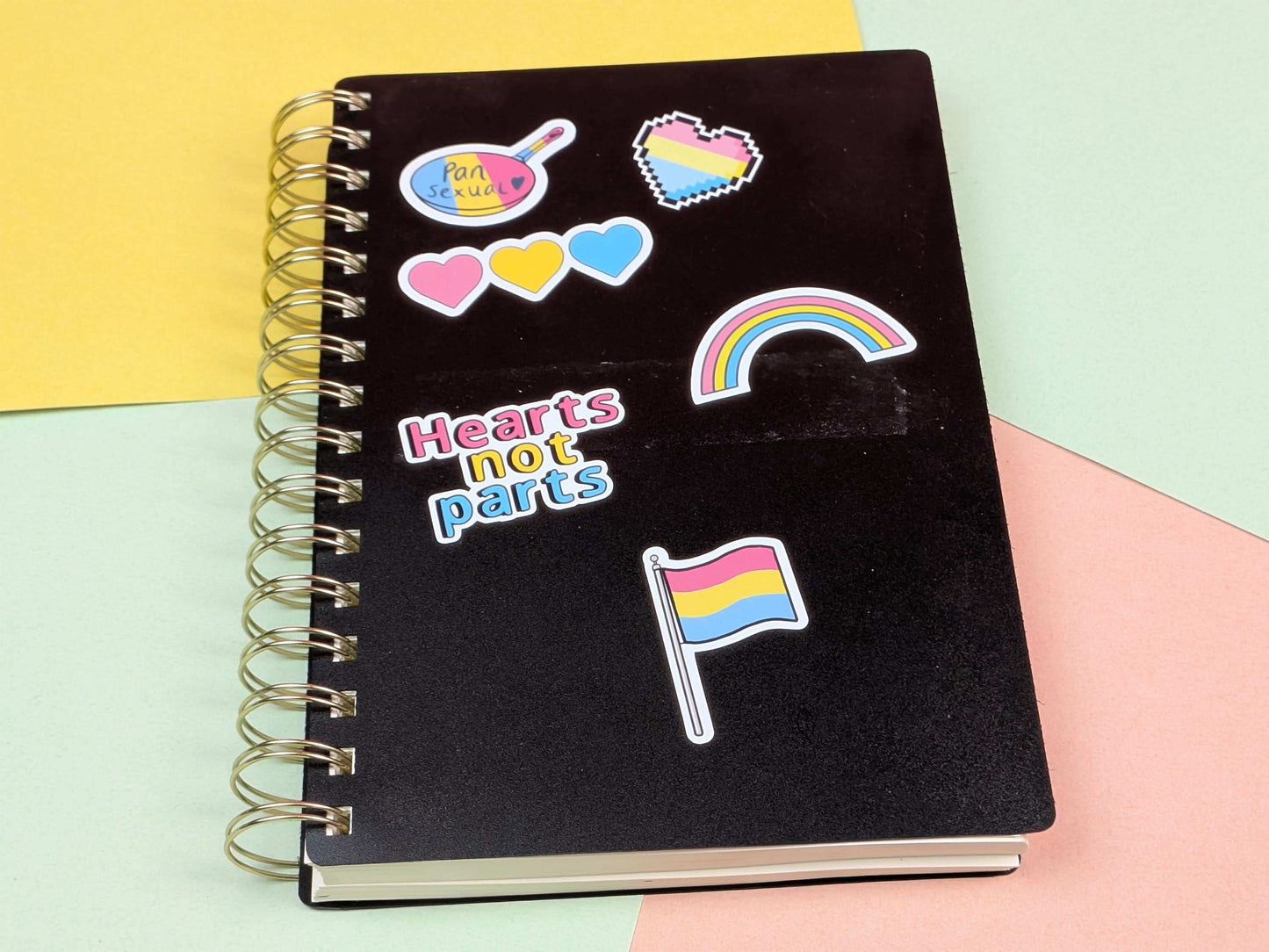 Black notebook with colorful stickers on a multicolored background