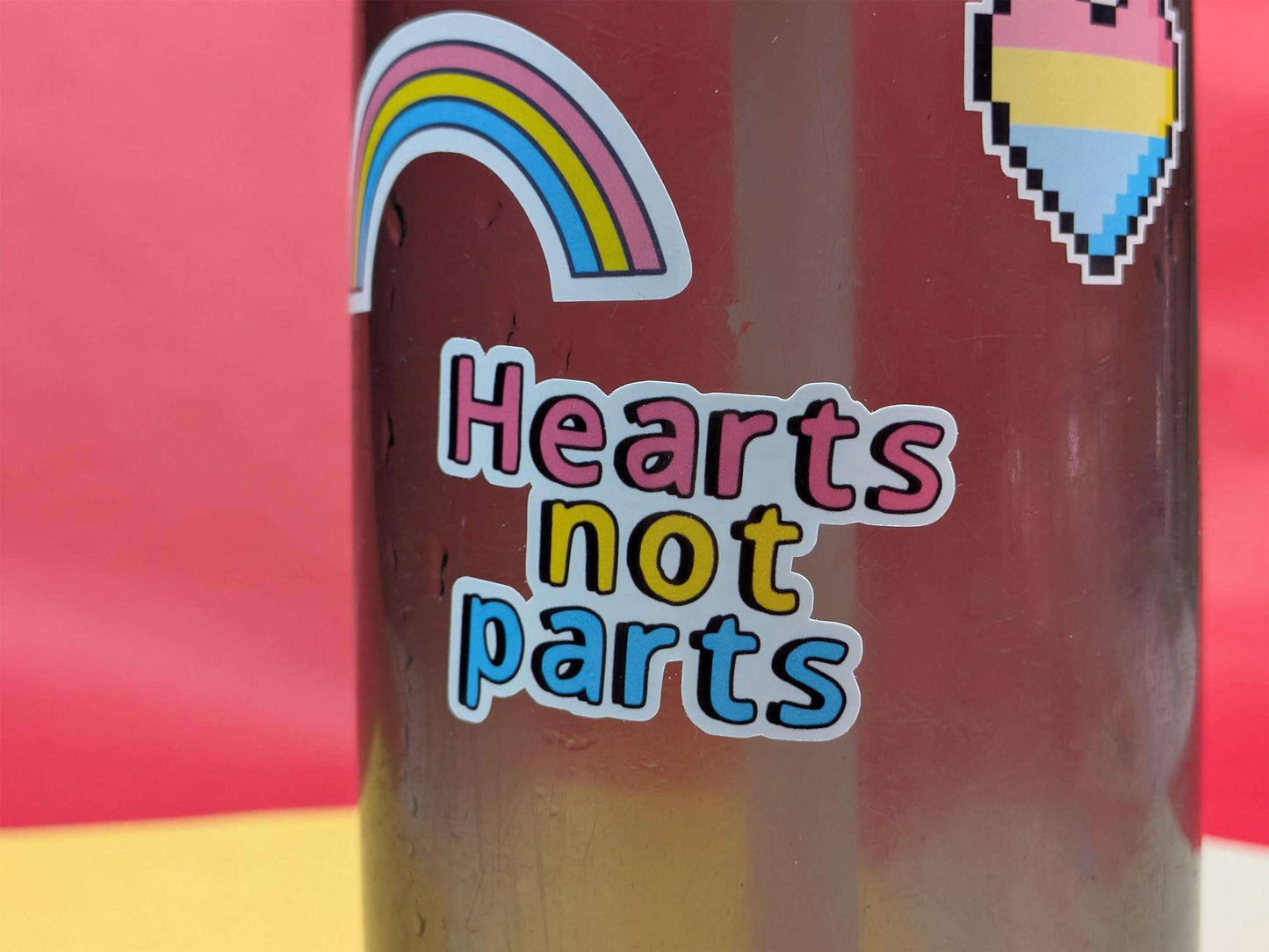 Sticker with 'Hearts not parts' text on a colorful background