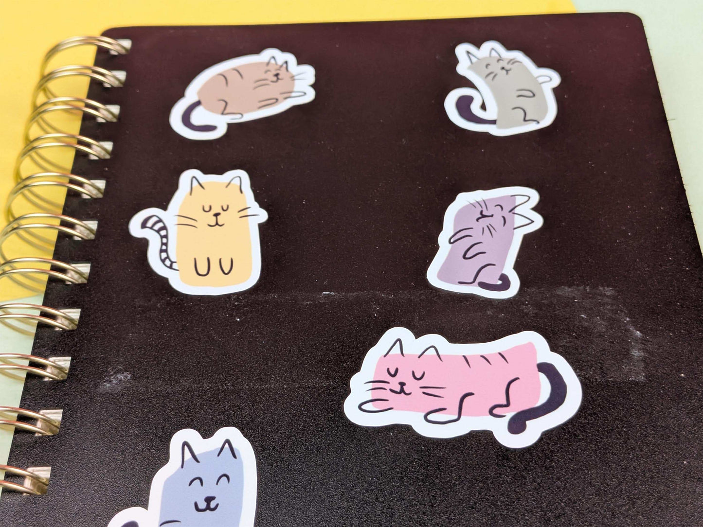 Cat shaped stickers on a black notebook