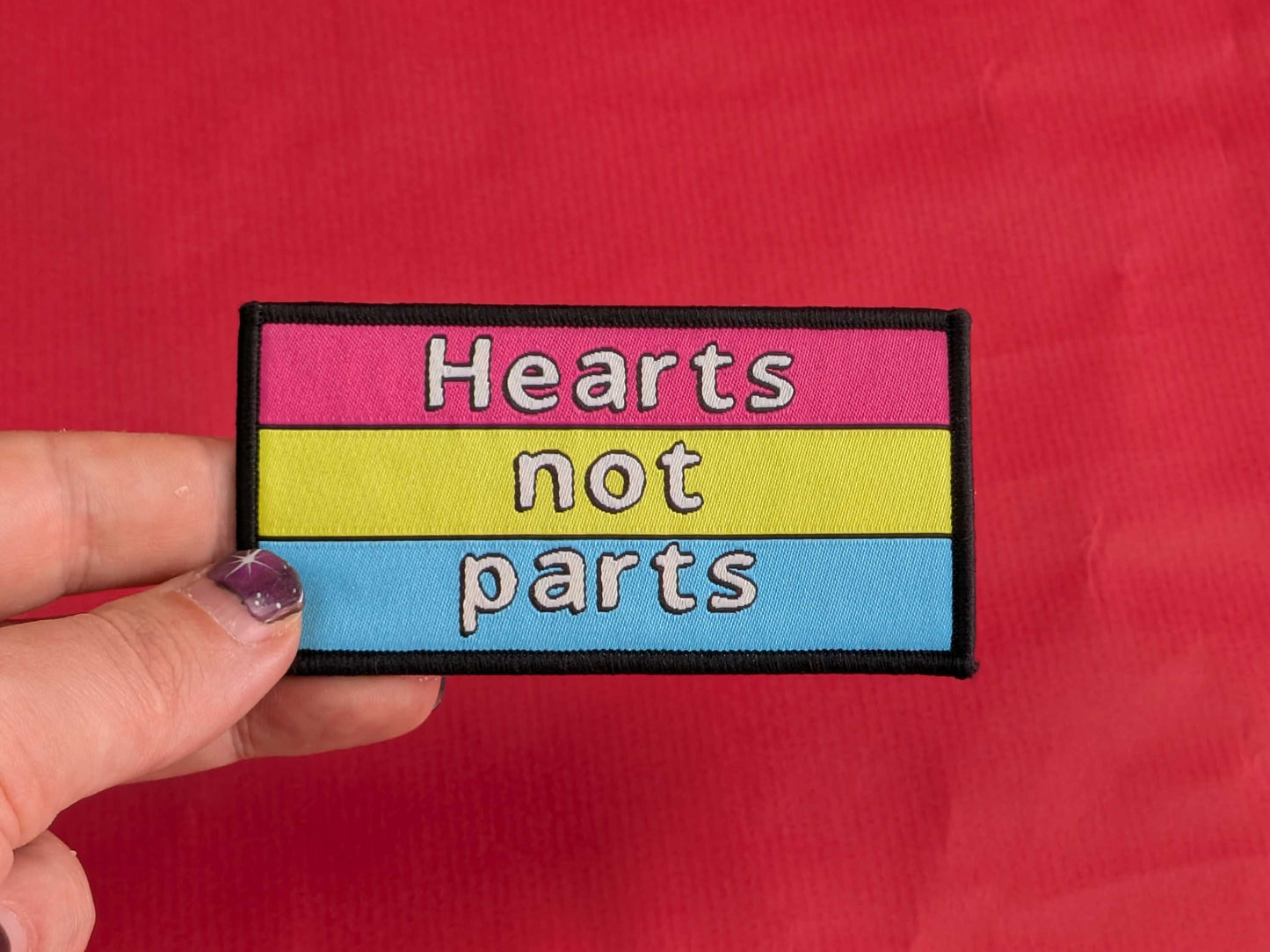Patch with 'Hearts not parts' text on a red background