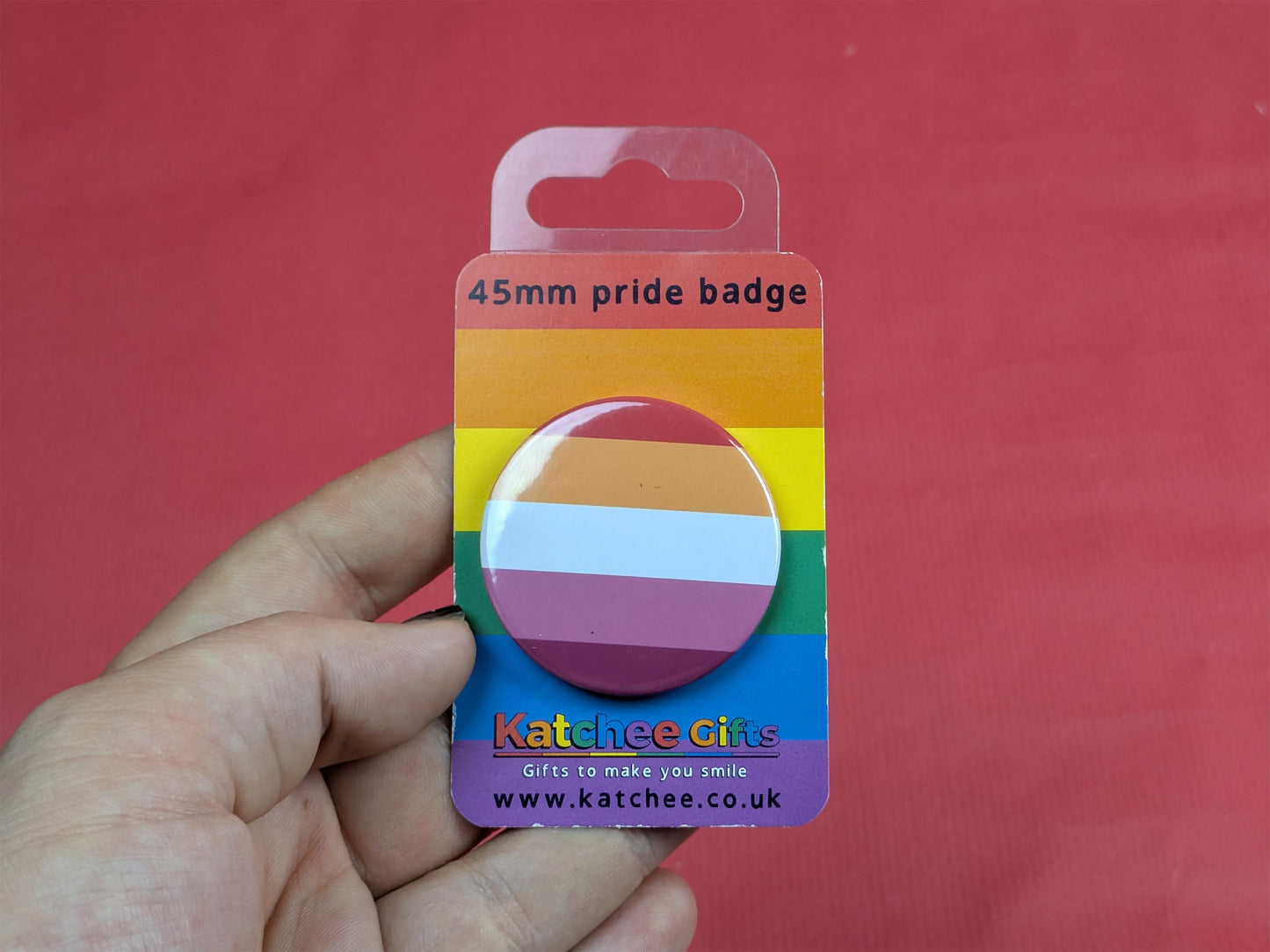 lesbian pride badge on a Katchee Gifts card against a red background