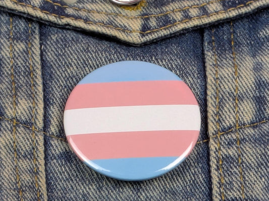 Trans flag pin badge on denim background