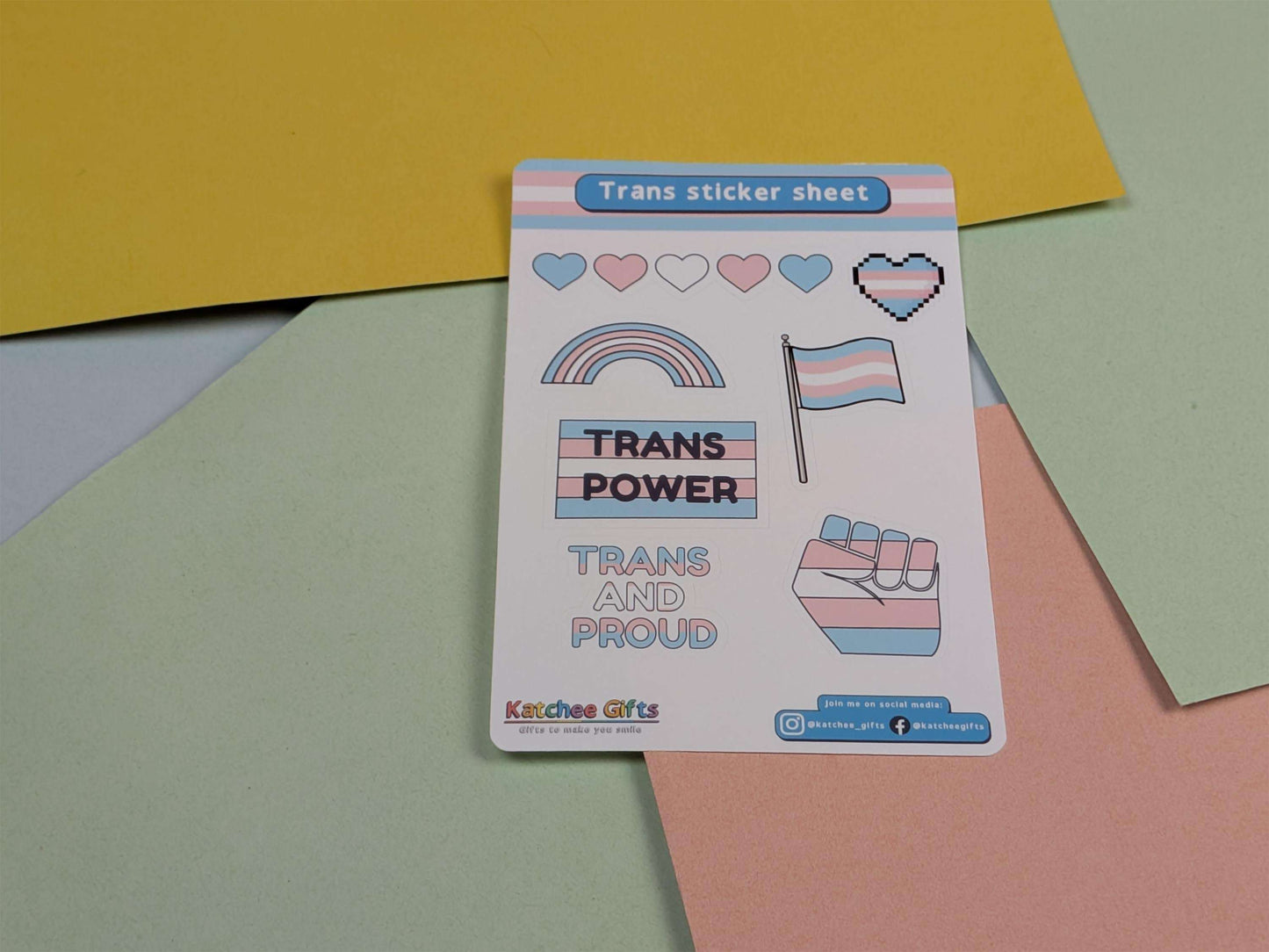 Trans sticker sheet with pride-themed designs on a colorful background