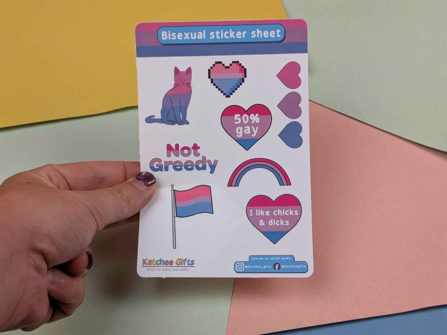 Bisexual sticker sheet held by a hand with colorful background