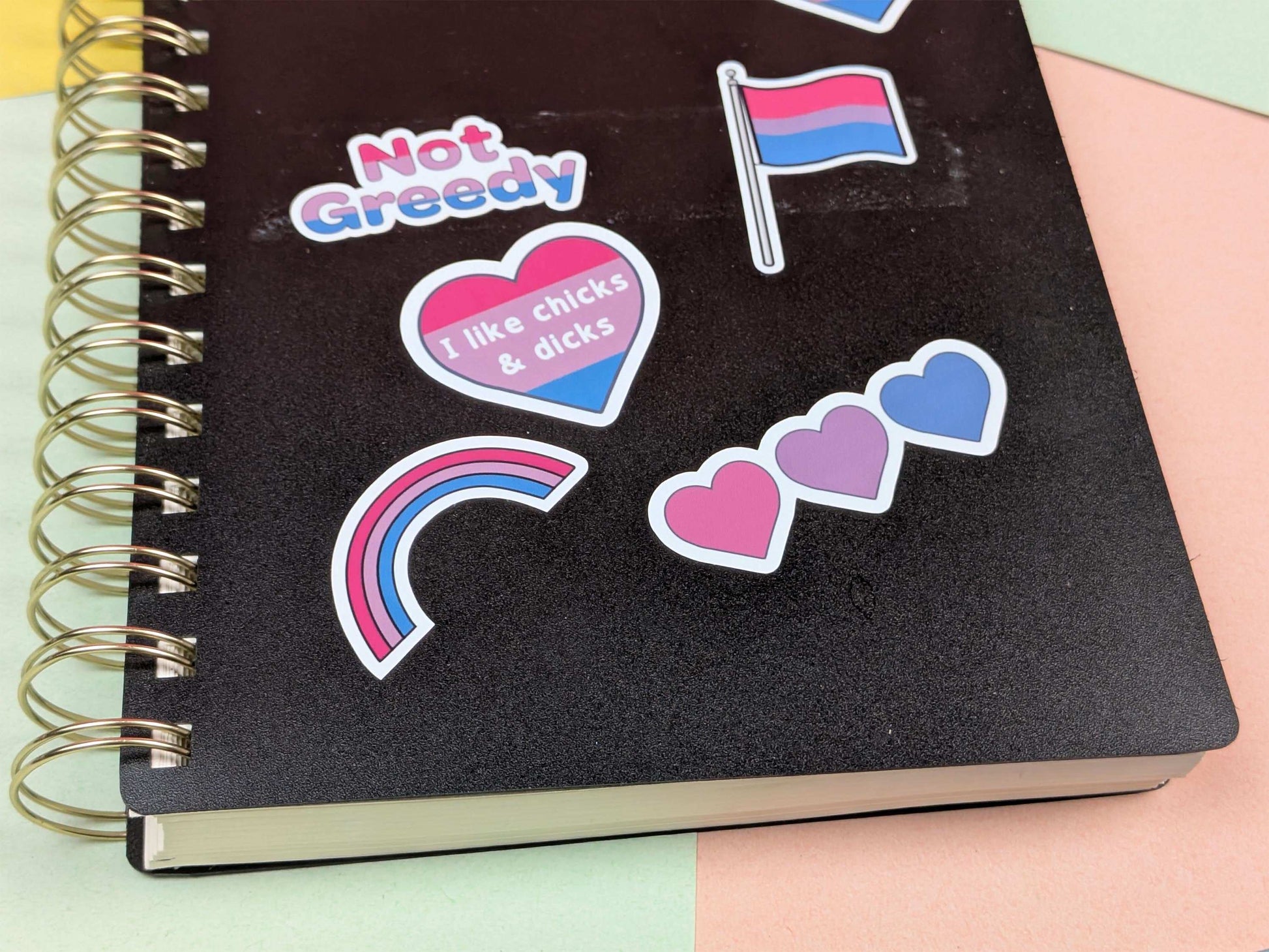 Black notebook with colorful stickers on a multicolored background