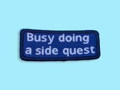 Blue patch with white text 'Busy doing a side quest' on a light blue background