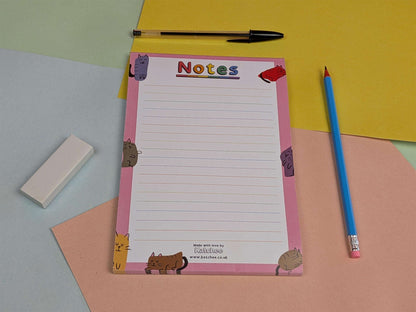 Notepad with animal illustrations on a colorful background with a pen and eraser.