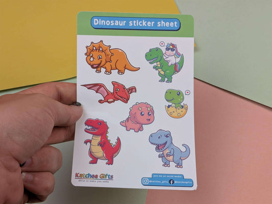 Dinosaur sticker sheet held by a hand with a colorful background