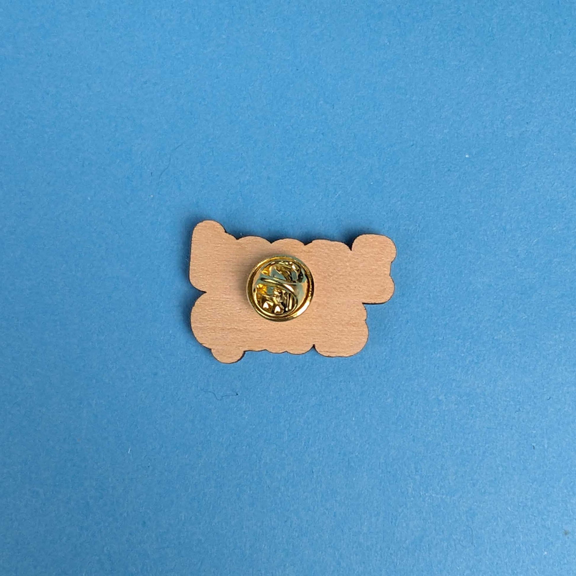 Back of a wooden pin, showing the butterfly clasp