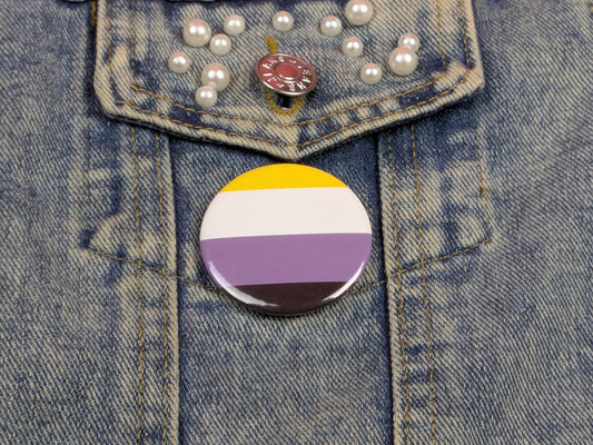 Button with a non-binary pride flag on a denim jacket