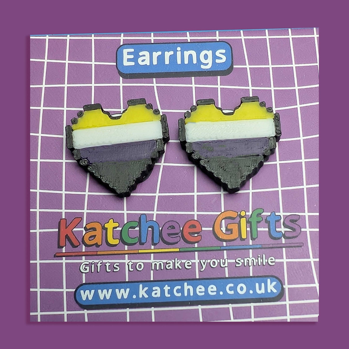 Heart-shaped earrings with a colorful design on a purple grid background with 'Katchee Gifts' branding.