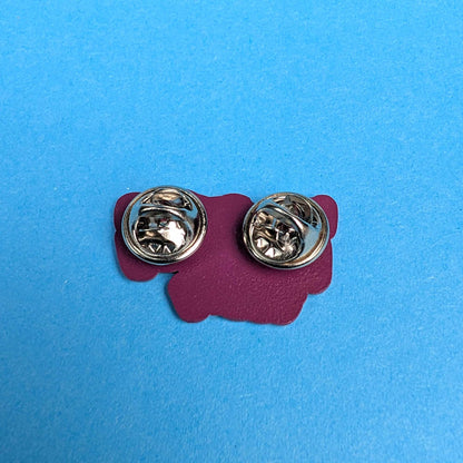 A pair of silver-tone oval lapel pins displayed on a magenta backing card against a bright blue background.