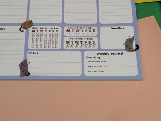 Planner with daily trackers and doodles on a plain background