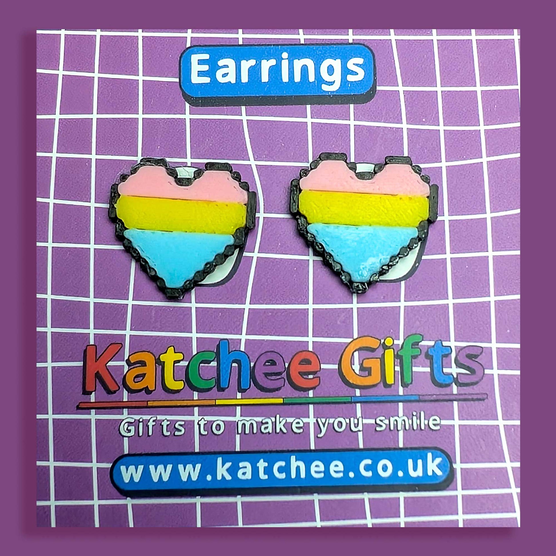 Heart-shaped earrings with a rainbow design on a Katchee Gifts branded card.