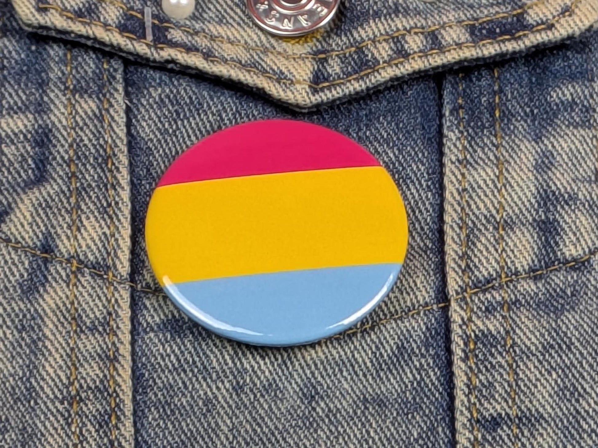 Pansexual flag button badge on a denim jacket