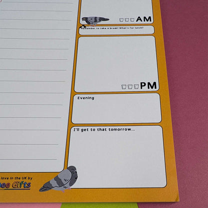 A close-up of a pigeon themed daily planner notepad with lined writing space, labeled AM and PM sections, an Evening box, and a 'I'll get to that tomorrow.
