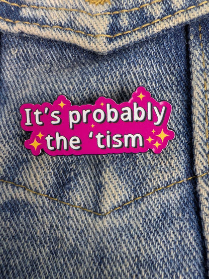 Pin with 'It's probably the 'tism' pin on a denim background