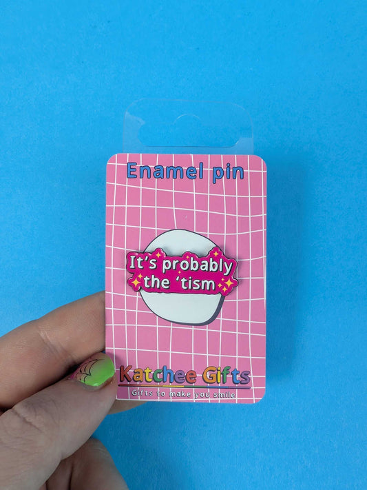Enamel pin packaging with a pink and white design on a blue background