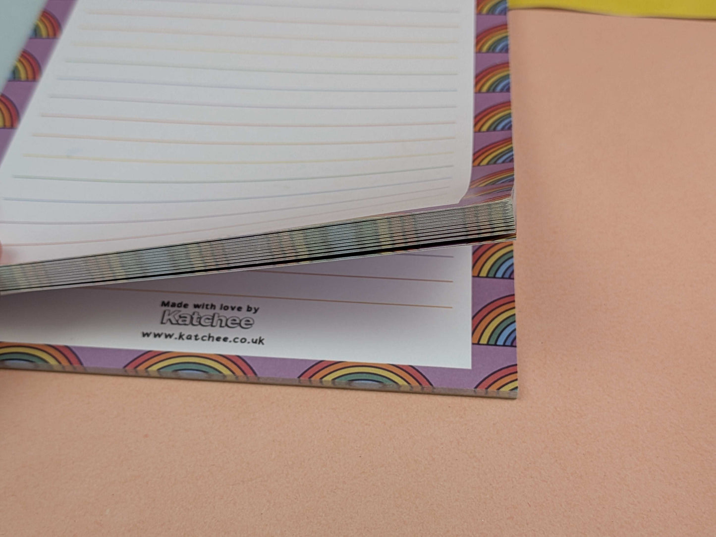 Notebook with rainbow design on a pink background