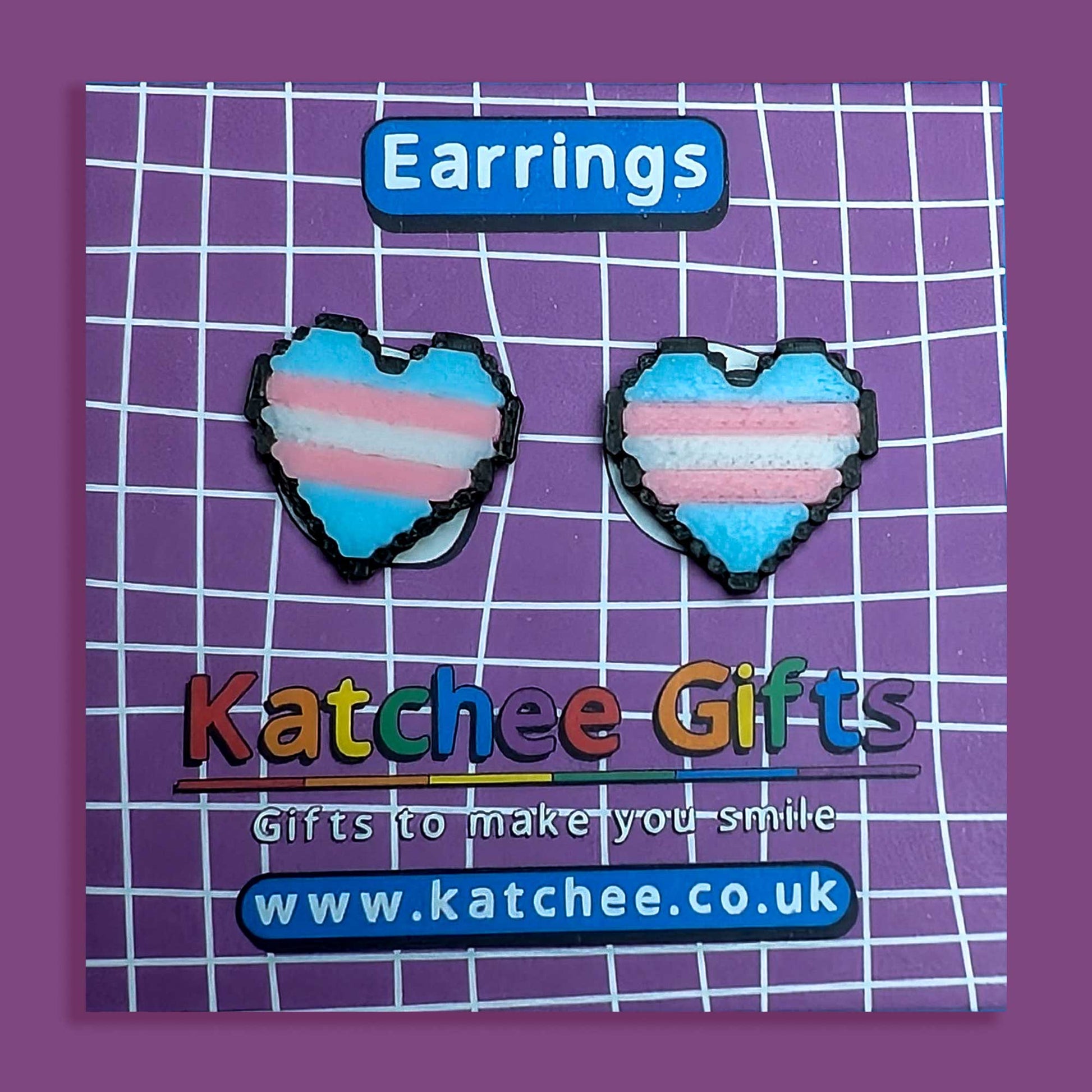 Heart-shaped earrings with a transgender flag design on a Katchee Gifts branded card.