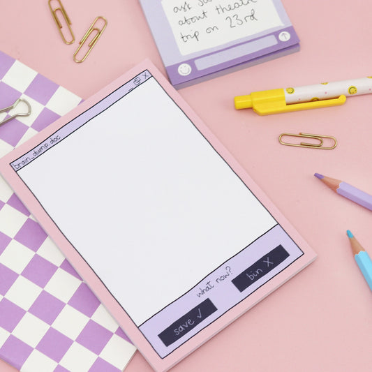 Notepad with digital interface design on a pink background with stationery items.