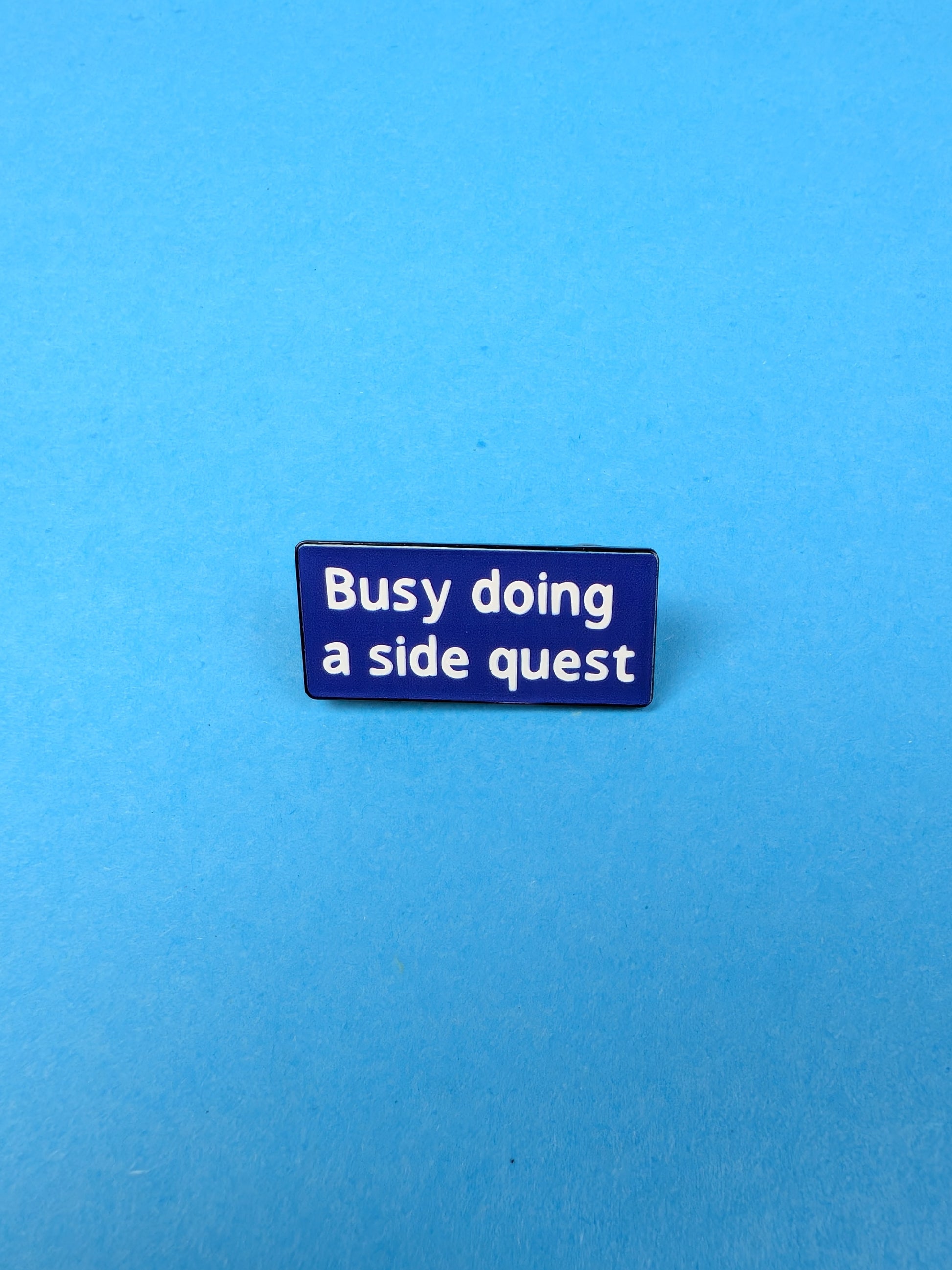 Blue badge with white text 'Busy doing a side quest' on a blue background