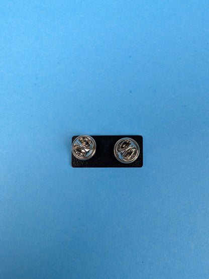 back of enamel pin with butterfly clasps against a blue background