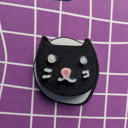 Black cat-shaped object on a purple grid background