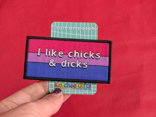 Iron-on patch with text 'I like chicks & dicks' held over a red background