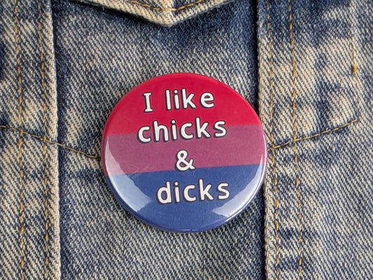 Button badge with 'I like chicks & dicks' text on a denim background