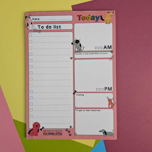 A dog-themed daily planner notepad with a pink border, featuring sections for a to-do list, morning, evening, and tomorrow planning, decorated with cartoon dog illustrations, shown on a colorful background.