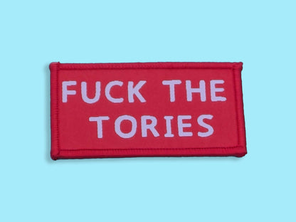 Red patch with white text 'FUCK THE TORIES' on a light blue background