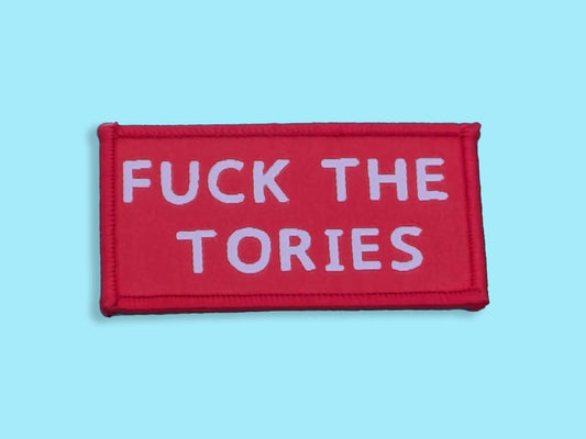 Red patch with white text 'FUCK THE TORIES' on a light blue background