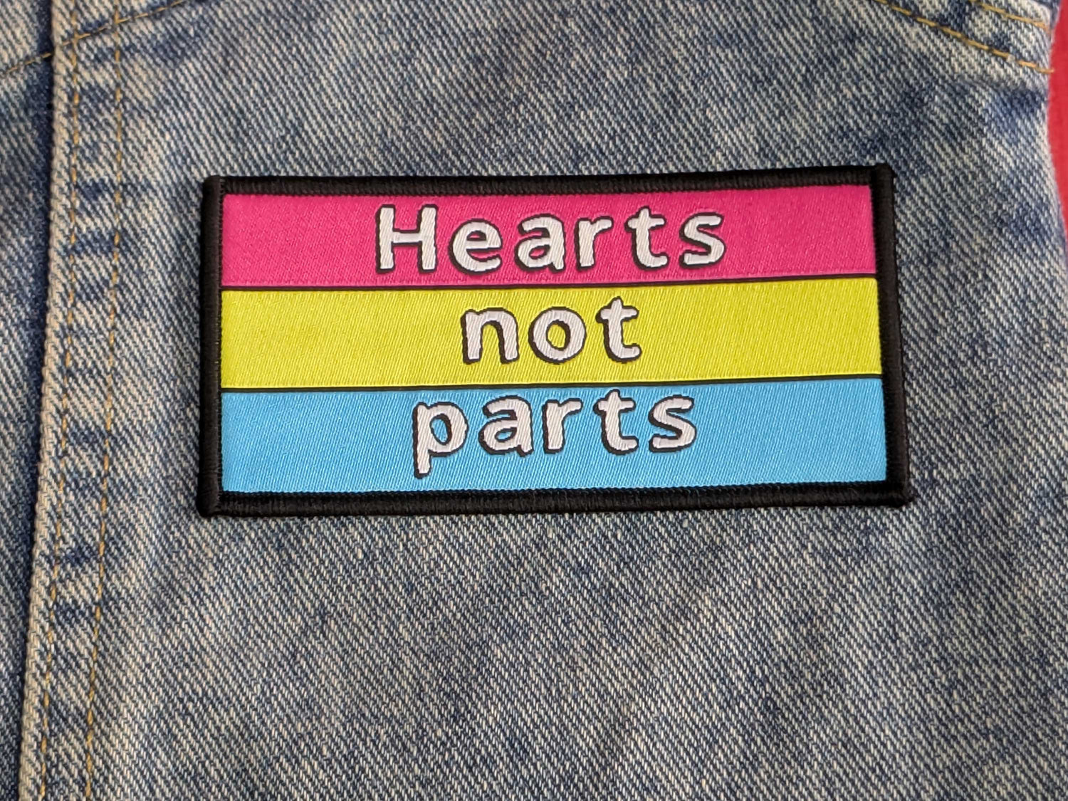 Patch with 'Hearts not parts' text on a denim background