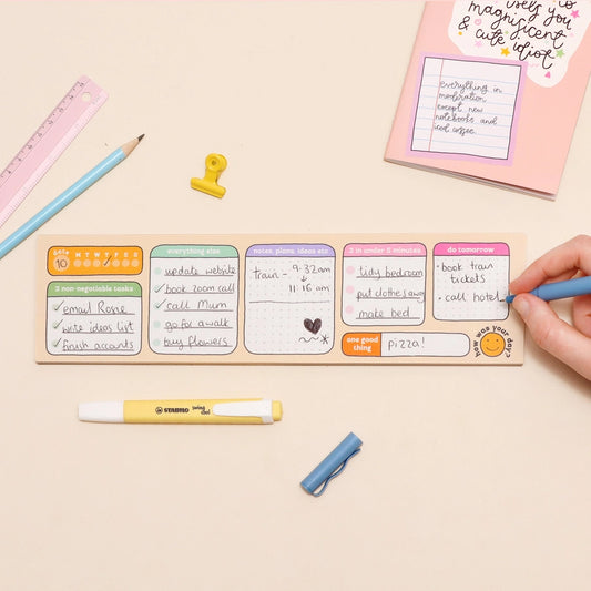 Colorful sticky notes on a wooden board with stationery items on a beige background