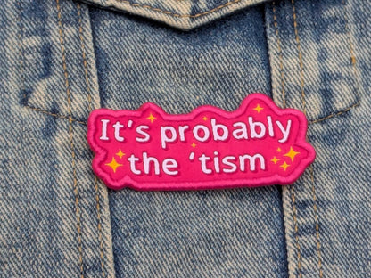 Pink patch with text 'It's probably the 'tism' on a denim background