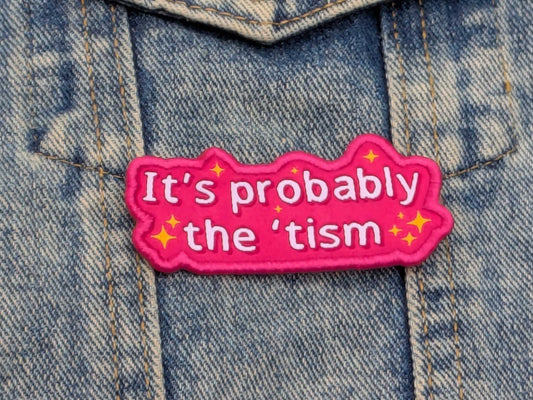 Pink patch with text 'It's probably the 'tism' on a denim background